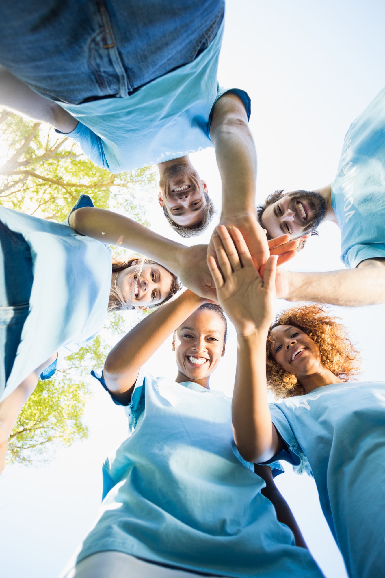 Portrait of volunteer group forming a huddle.