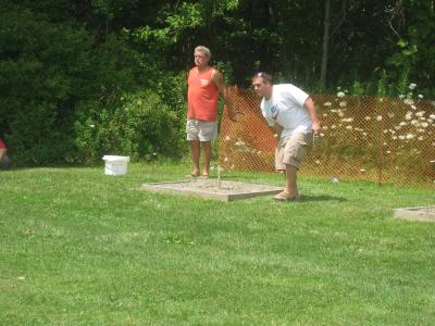 Individuals playing corn hole at community day