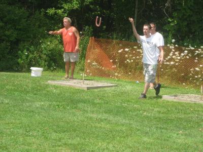 Individuals playing corn hole at community day